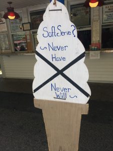 Sign shaped like an ice cream cone, which reads "Soft Serve?  Never Have, Never Will"